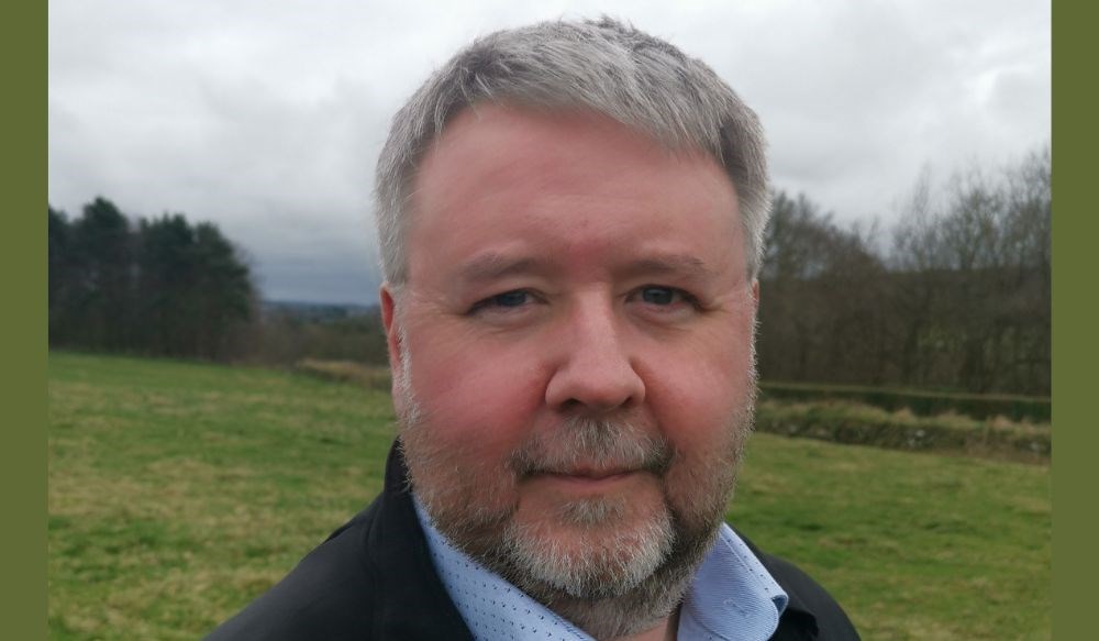 Close up headshot of a man (Glen Nimmo) in a grassy field.